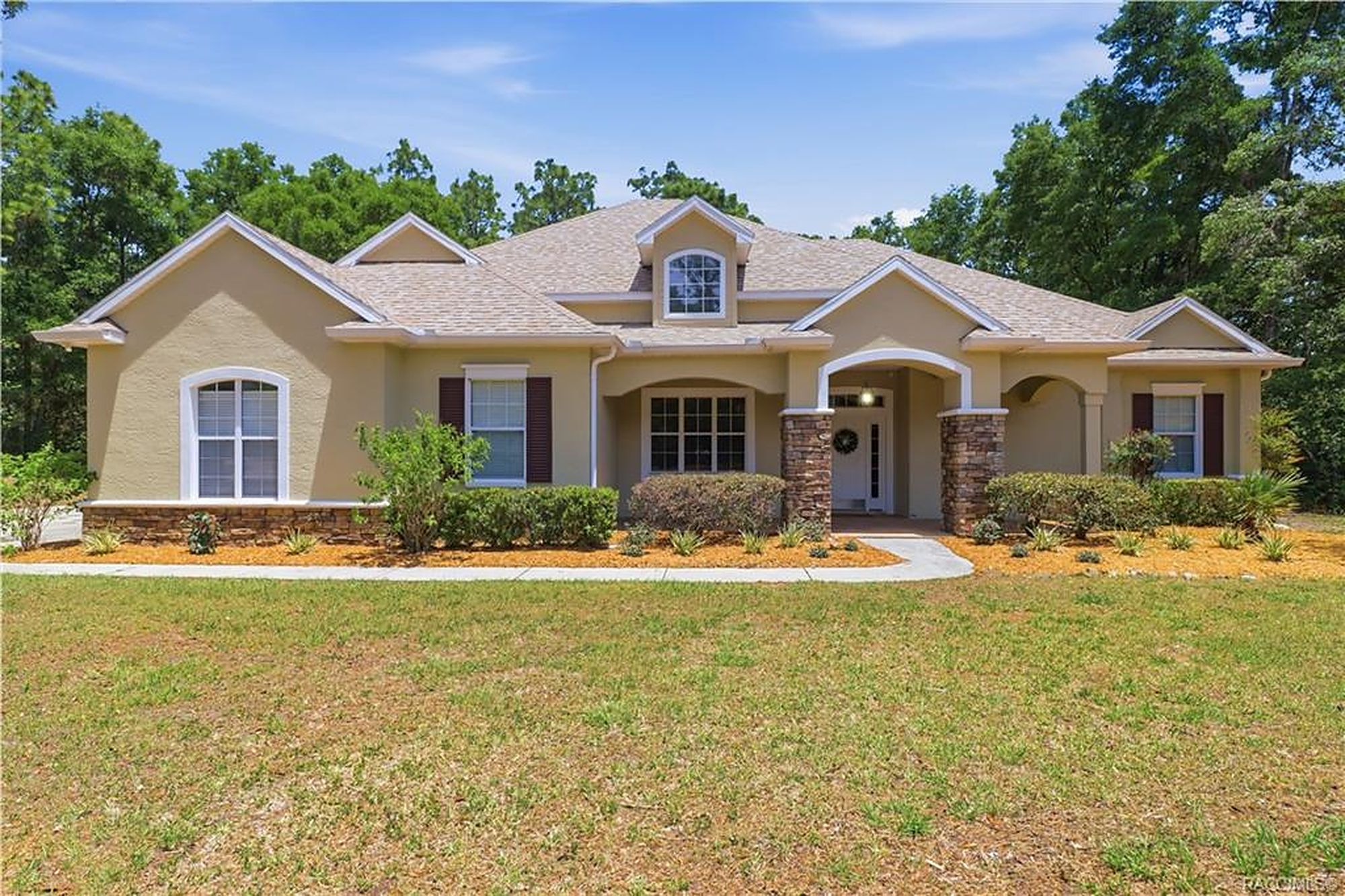 Stucco single family home with stone columns and mature pines, managed by Roam Management in Citrus County, Florida