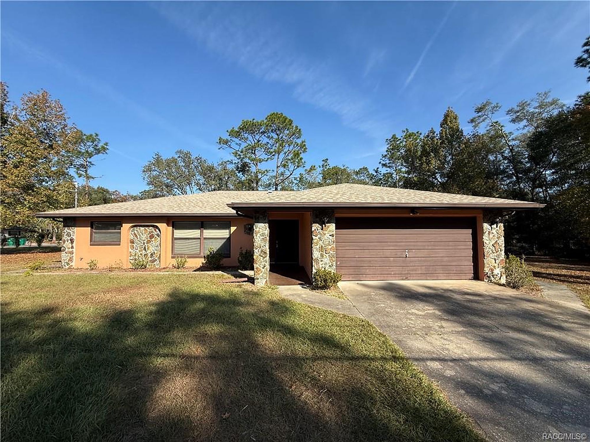 Three bedroom block home with stone accents and two car garage in Citrus Springs, Florida