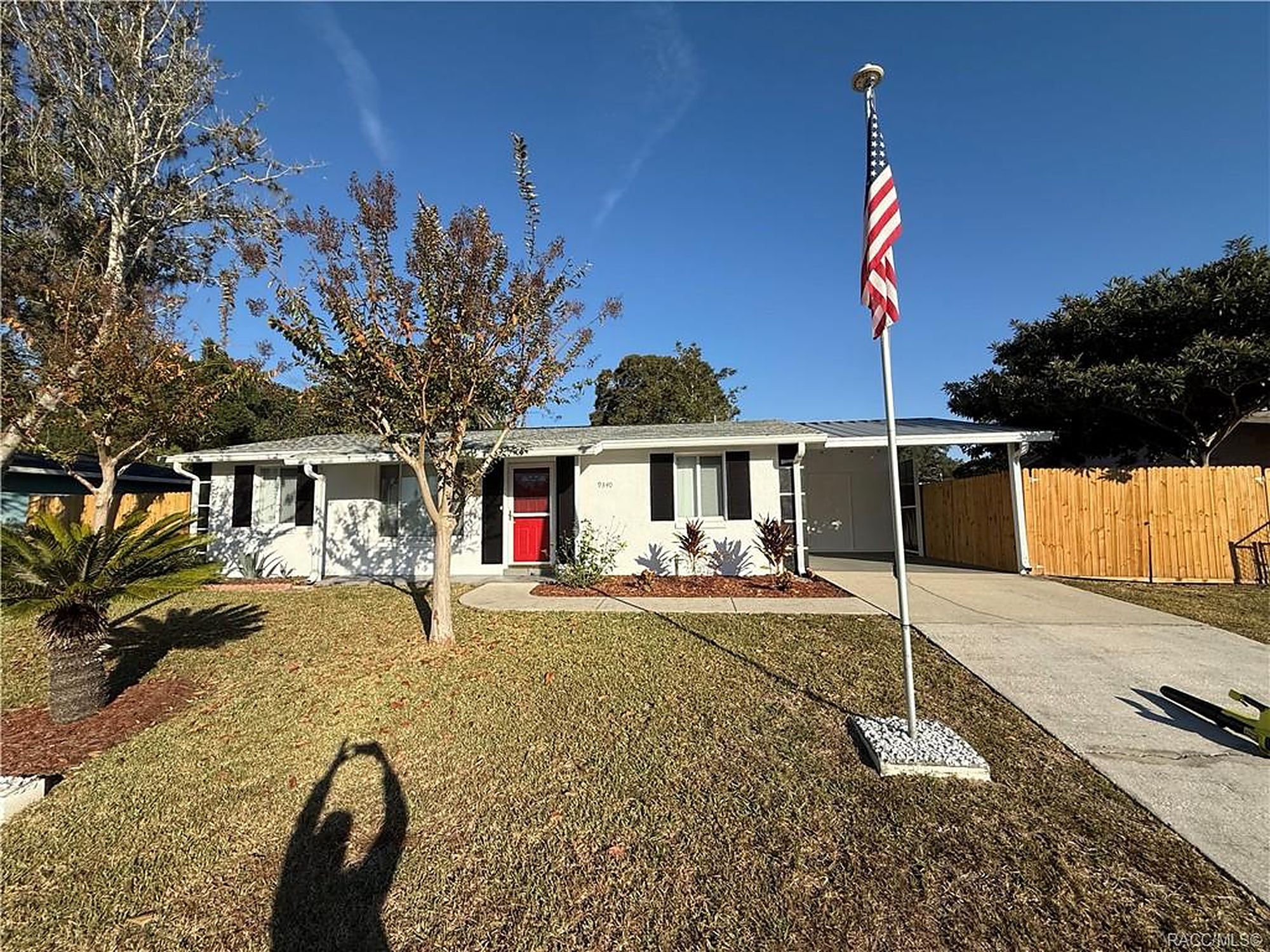 Concrete block ranch rental with carport and flagpole in Homosassa, Florida
